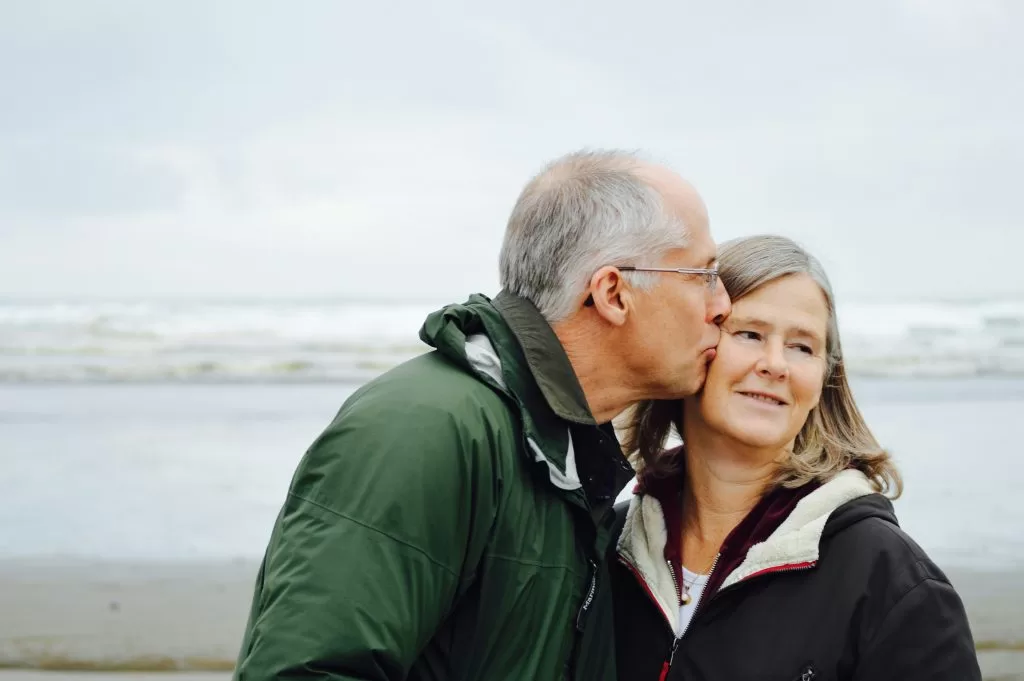 An elderly couple sharing an affectionate moment by the sea