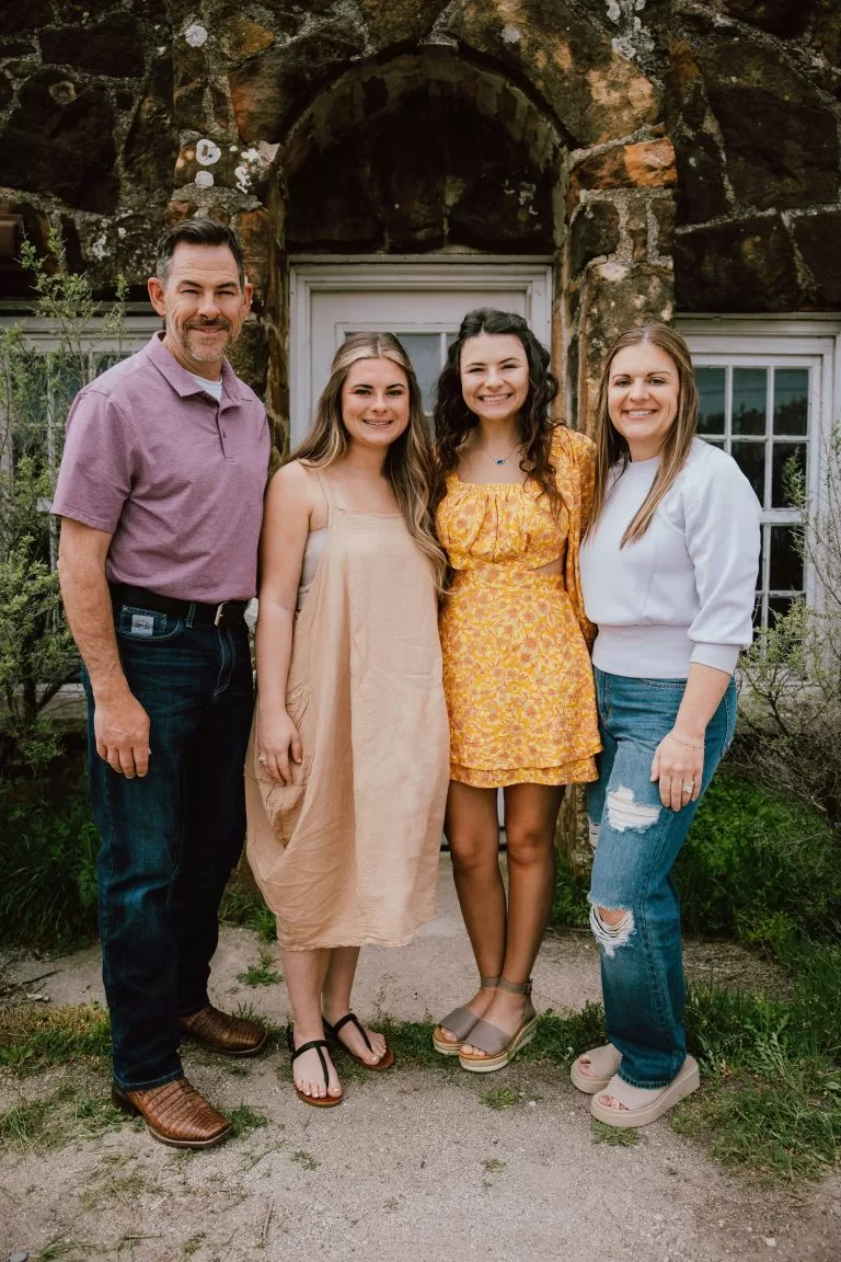 A family of four smiling together outdoors