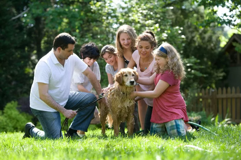 A multi-generational family together outdoors with their dog