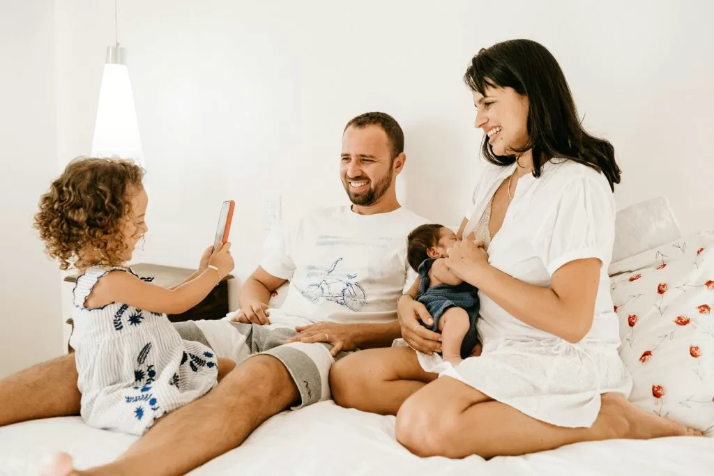New parents at home with their children, including a newborn